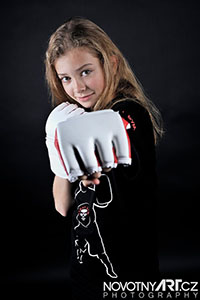 Portrétní lifestylová a reklamní fotografie. Sportovní portrét dívky v rukavicích.